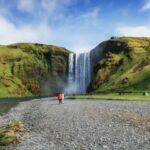 Skogafoss en Islande en pleine journée avec des visiteurs au pied de la cascade